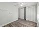 This bedroom offers a ceiling fan, closet with paneled doors and wood-look flooring at 5724 Casson Ave, New Port Richey, FL 34652