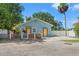 Cozy light blue one-story house featuring a fenced front yard and yellow door detail at 5724 Casson Ave, New Port Richey, FL 34652