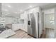 Eat-in kitchen boasts stainless steel refrigerator, granite countertops, and white cabinets at 5724 Casson Ave, New Port Richey, FL 34652