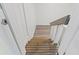 A partial view of the stairway with wood stairs and white risers and handrails at 5724 Casson Ave, New Port Richey, FL 34652