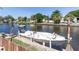 Boat on lift next to canal with lush greenery and nearby houses, perfect for waterfront living at 5824 Portsmouth Dr, Tampa, FL 33615