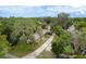Aerial view of property surrounded by lush trees and expansive green spaces at 6019 Wyoming Ave, New Port Richey, FL 34653
