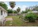 Backyard with lush lawn, garden beds, and a wooden fence for privacy at 6019 Wyoming Ave, New Port Richey, FL 34653