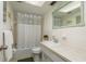Bathroom featuring a tub with shower, a decorative mirror, and a neutral color palette at 6019 Wyoming Ave, New Port Richey, FL 34653