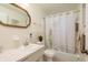 Bright bathroom featuring shower and tub combo with shower curtain and decorative wall mirror at 6019 Wyoming Ave, New Port Richey, FL 34653