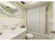 Bathroom featuring a tub with shower, a decorative mirror, and a neutral color palette at 6019 Wyoming Ave, New Port Richey, FL 34653