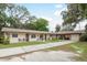 A charming, well-maintained exterior with a long driveway and a garage, nestled amongst mature trees at 6019 Wyoming Ave, New Port Richey, FL 34653