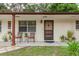 Inviting front porch with seating area and well maintained landscaping create curb appeal at 6019 Wyoming Ave, New Port Richey, FL 34653