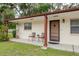 Welcoming front porch with chairs, lush lawn, and manicured landscaping at 6019 Wyoming Ave, New Port Richey, FL 34653