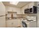 Well-lit kitchen equipped with a microwave and an electric range oven at 6019 Wyoming Ave, New Port Richey, FL 34653