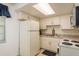 Bright kitchen features white cabinets, tile backsplash, and essential appliances at 6019 Wyoming Ave, New Port Richey, FL 34653