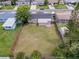 Aerial view of a large, fenced backyard with green grass, connected to a cozy home and neighborhood at 6341 Hyperion Dr, Port Richey, FL 34668