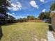 Large fenced backyard featuring lush green grass and mature trees at 6341 Hyperion Dr, Port Richey, FL 34668