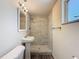 Bathroom with a pedestal sink, shower with gray stone surround and mosaic floor at 6341 Hyperion Dr, Port Richey, FL 34668