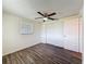 Bedroom featuring wood floors, a ceiling fan, a window, and a closet at 6341 Hyperion Dr, Port Richey, FL 34668