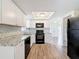 Modern kitchen with white cabinets, granite countertops, and stainless steel appliances at 6341 Hyperion Dr, Port Richey, FL 34668