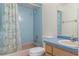Retro blue bathroom featuring a vanity with wood cabinets and a shower with blue tile at 7122 Barclay Ave # B, Spring Hill, FL 34609