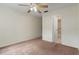 Bedroom featuring carpet, a ceiling fan, and a doorway to an ensuite bathroom at 7122 Barclay Ave # B, Spring Hill, FL 34609
