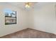 Bright bedroom with carpet, a ceiling fan, and a large window overlooking greenery at 7122 Barclay Ave # B, Spring Hill, FL 34609