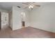 Bedroom featuring carpet, a ceiling fan, and doorways to a bathroom and closet at 7122 Barclay Ave # B, Spring Hill, FL 34609