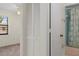 Hallway leading to a carpeted bedroom and a full bathroom with blue tile at 7122 Barclay Ave # B, Spring Hill, FL 34609