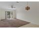 Open living area featuring a ceiling fan, unique light fixture, and sliding door to backyard at 7122 Barclay Ave # B, Spring Hill, FL 34609