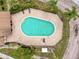 Overhead shot of a large community pool with brick surround, lounge seating, and beautiful landscaping at 7133 Trenton Pl, New Port Richey, FL 34653