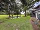 Large backyard features mature trees and a pond with view of the screened in porch at 7133 Trenton Pl, New Port Richey, FL 34653