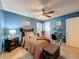 Blue bedroom featuring a ceiling fan, light hardwood floors, and a bright window at 7133 Trenton Pl, New Port Richey, FL 34653