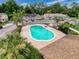 An aerial view of a community pool with chairs and lush landscaping showcasing a recreational amenity at 7133 Trenton Pl, New Port Richey, FL 34653