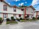 Charming white townhouse with brick accents boasts lush landscaping and a welcoming front entrance at 7133 Trenton Pl, New Port Richey, FL 34653