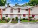 Inviting townhouse boasts vibrant landscaping and a charming white facade with brick accents at 7133 Trenton Pl, New Port Richey, FL 34653