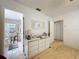 Hallway with hardwood floors leading to a bright bathroom with tiled shower and vanity area at 7133 Trenton Pl, New Port Richey, FL 34653