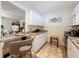 Modern kitchen boasts white cabinetry, stainless steel appliances, and a breakfast bar seating area at 7133 Trenton Pl, New Port Richey, FL 34653