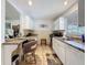 Bright kitchen featuring white cabinets, tile flooring, and a cozy eat-in breakfast bar area at 7133 Trenton Pl, New Port Richey, FL 34653