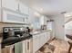 Bright kitchen features white cabinetry, granite countertops, and stainless steel microwave at 7133 Trenton Pl, New Port Richey, FL 34653
