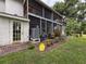 The back patio includes a screened in porch, and brick landing with potted plants at 7133 Trenton Pl, New Port Richey, FL 34653