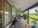 A cozy screened in porch shows a view of a waterway along with comfortable chairs and plants at 7133 Trenton Pl, New Port Richey, FL 34653