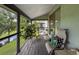 A cozy screened in porch shows a view of a waterway along with comfortable chairs and plants at 7133 Trenton Pl, New Port Richey, FL 34653
