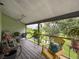 Relaxing screened porch with comfortable seating and scenic backyard views of lush greenery at 7133 Trenton Pl, New Port Richey, FL 34653