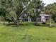 Expansive backyard view, perfect for outdoor activities, with a flowing creek, large trees, and a spacious lawn at 7135 Trenton Pl, New Port Richey, FL 34653