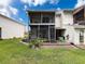 Exterior view of the home featuring a two-story screened lanai and well-manicured backyard at 7135 Trenton Pl, New Port Richey, FL 34653
