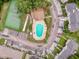 Aerial view of a sparkling community pool, tennis court, and surrounding residences, offering resort-style living at 7135 Trenton Pl, New Port Richey, FL 34653