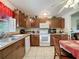 Traditional kitchen featuring wood cabinets and white appliances at 7135 Trenton Pl, New Port Richey, FL 34653