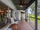 This beautiful screened-in porch features a ceiling fan, chairs, and peaceful views of the outdoors at 7135 Trenton Pl, New Port Richey, FL 34653