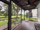 Charming screened porch featuring comfortable seating, views of the creek and lush backyard landscaping at 7135 Trenton Pl, New Port Richey, FL 34653