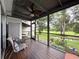 Cozy screened-in porch with nature views, ceiling fan, and outdoor seating, ideal for relaxation at 7135 Trenton Pl, New Port Richey, FL 34653
