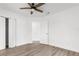Bedroom featuring wood-look floors, closet, ceiling fan, and a door leading to another room at 7192 Catalina St, Spring Hill, FL 34606