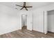 Bedroom featuring wood-look floors, closet, ceiling fan, and a door leading to another room at 7192 Catalina St, Spring Hill, FL 34606