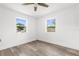 This bedroom features wood-look floors, a ceiling fan and two windows at 7192 Catalina St, Spring Hill, FL 34606